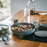 a wooden table topped with a bowl of food